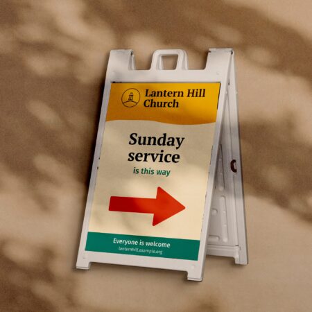 Sidewalk sign with an arrow for a church plant, a sample design on a plaster wall