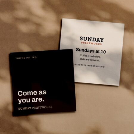 Square invite cards, front and back, in window light